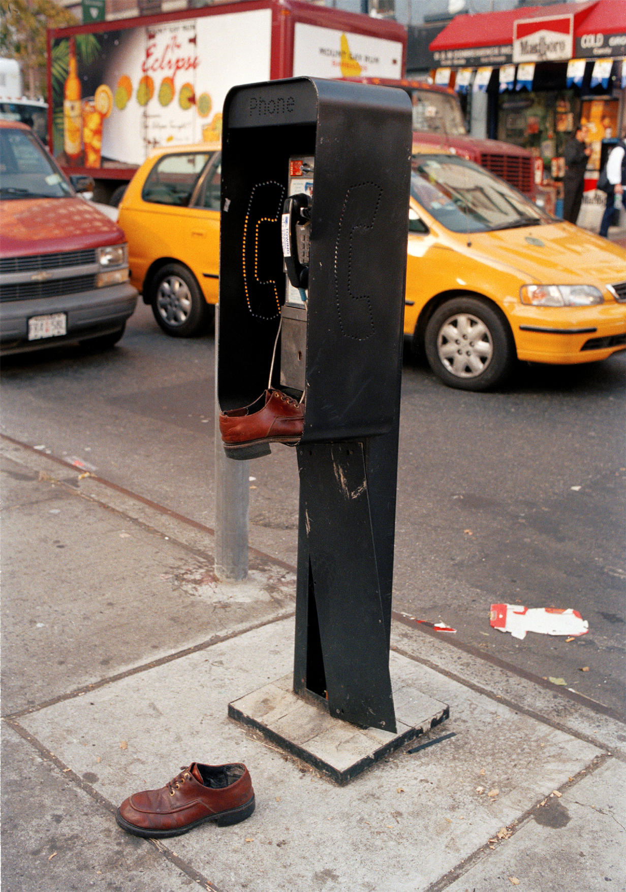 Straßenszene mit vergessenen Schuhen an einem öffentlichen Telefon. (c) Melanie Einzig 